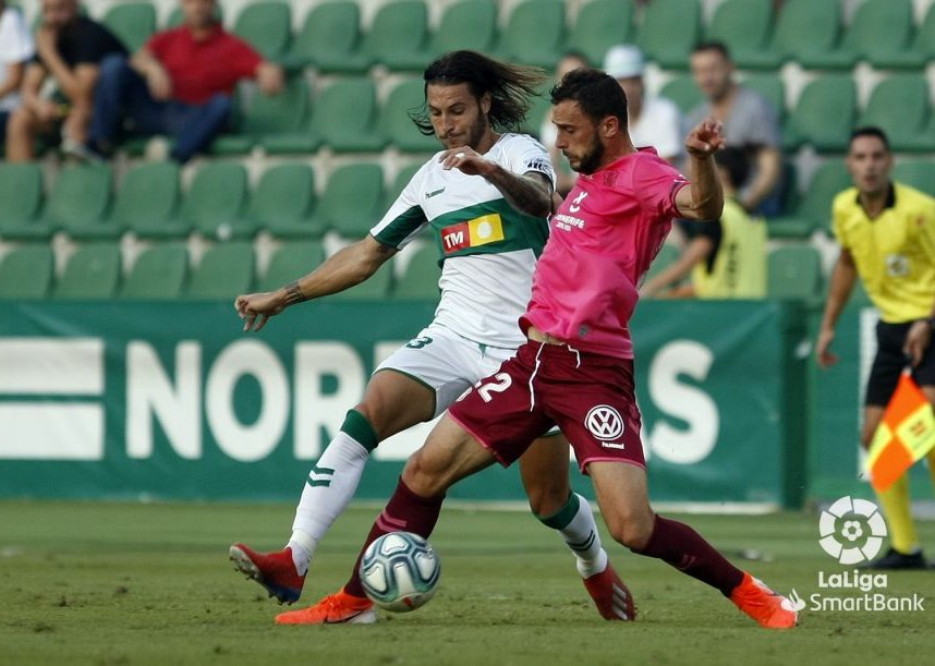 El jugador del Elche Juan Cruz pelea un balón durante un partido ante el Tenerife / LFP