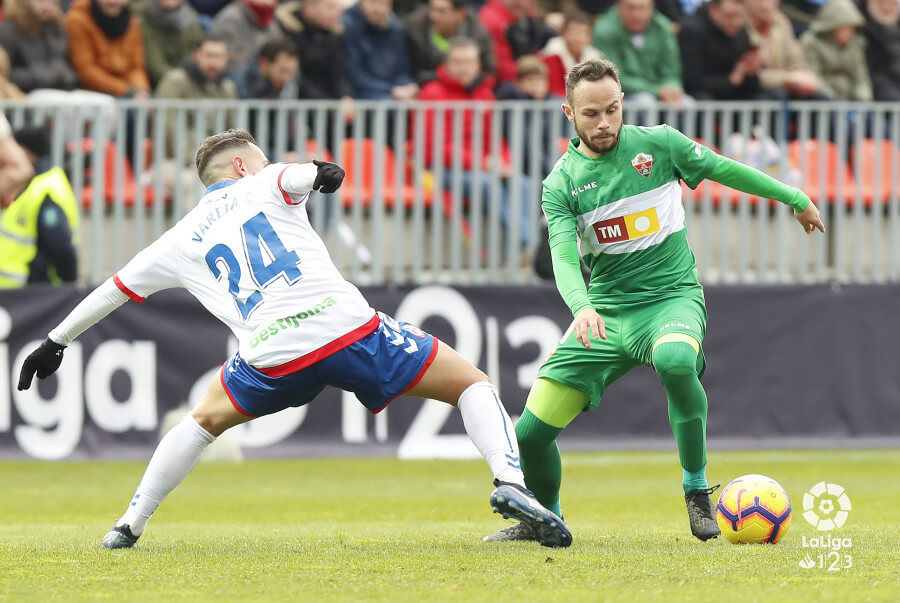 El jugador del Elche Iván Sánchez recorta a un rival durante un partido ante el Rayo Majadahonda / LFP