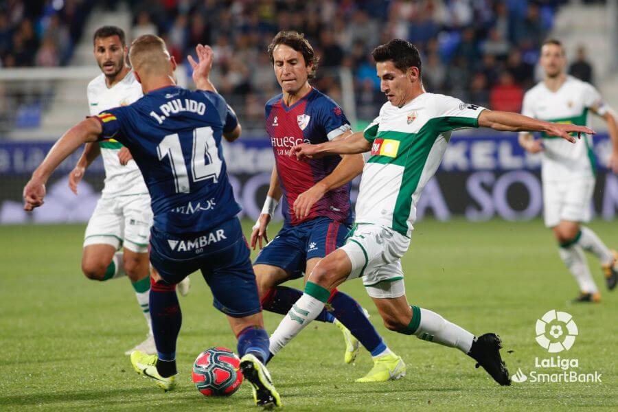 El jugador del Elche Pere Milla pelea un balón durante un partido ante el Huesca / LFP