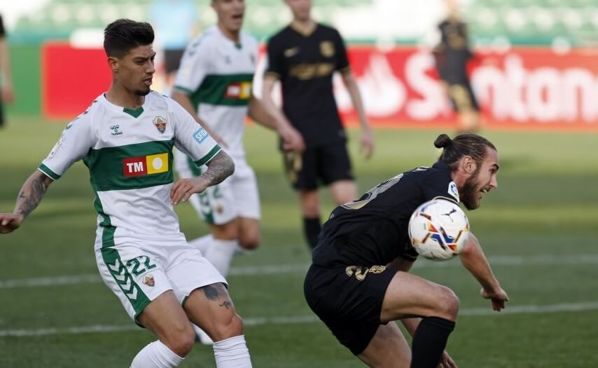 Los jugadores Rigoni y Mingueza disputan un balón durante un partido entre Elche CF y FC Barcelona / LaLiga